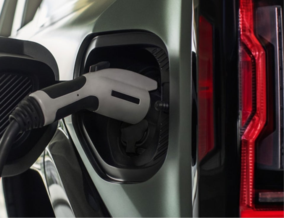 Close up of charging port with charger plugged in on a GMC Hummer EV SUV - DeVoe Buick GMC in Naples FL