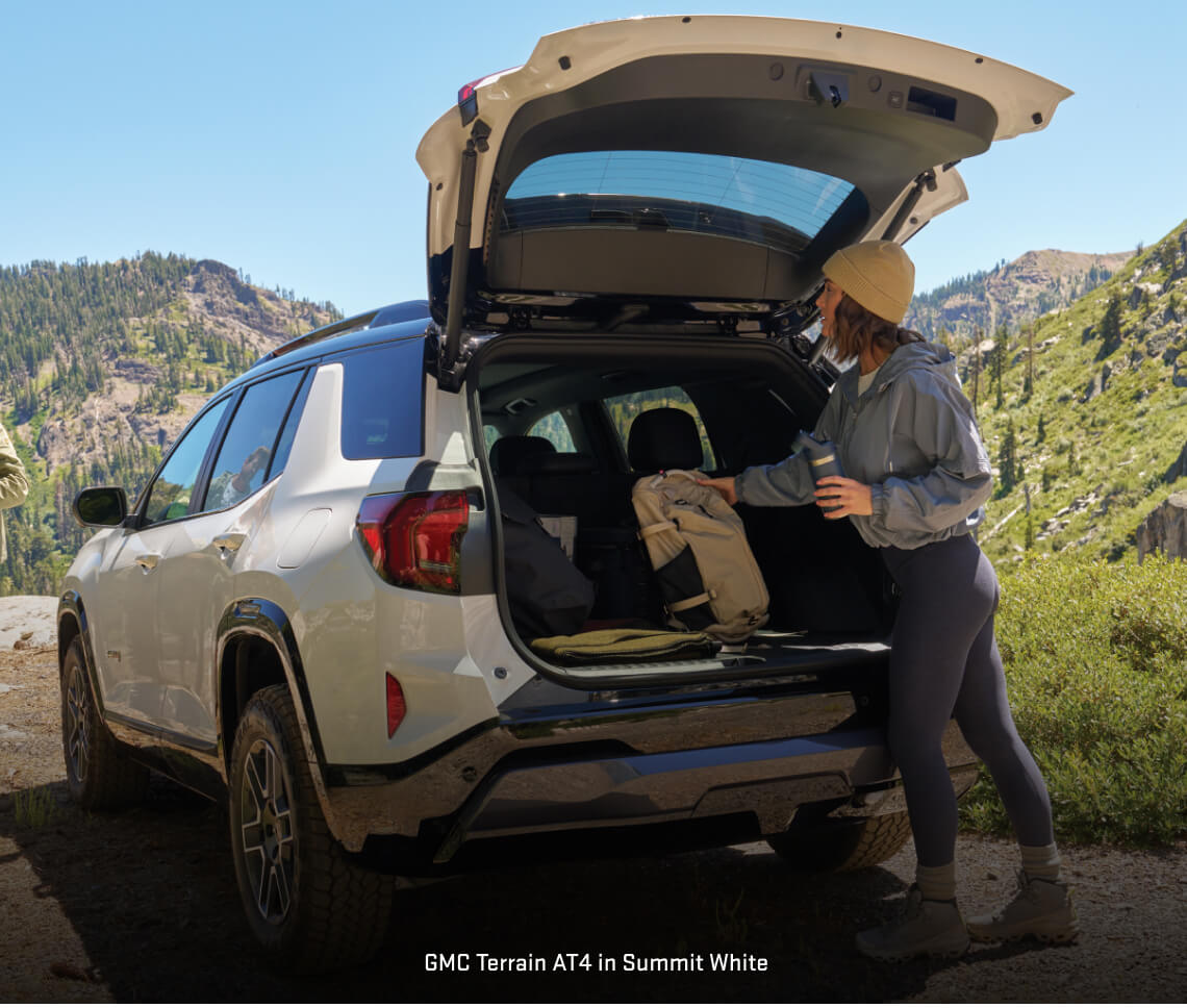 GMC Terrain AT4 opens its cargo liftgate on a mountain trail.