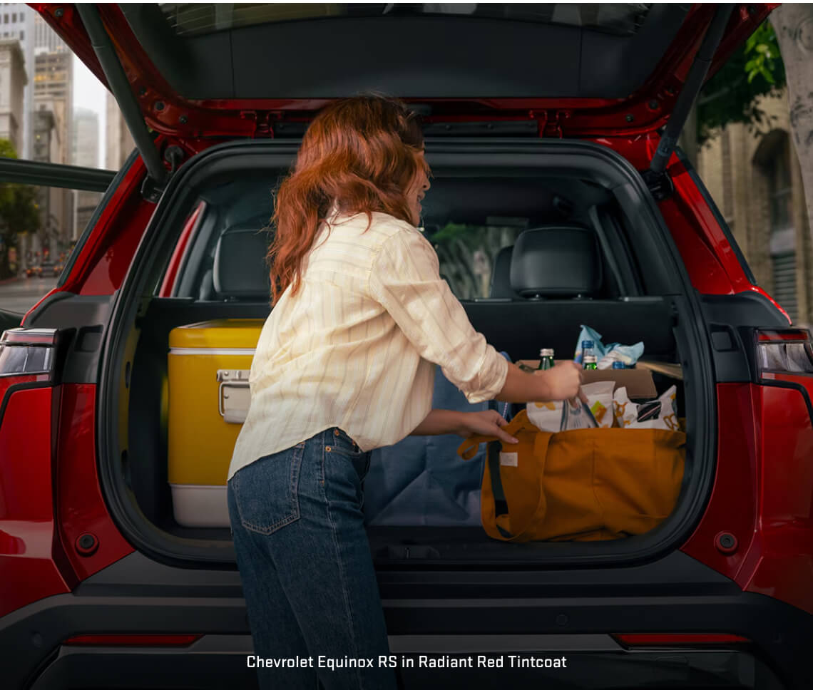 Chevrolet Equinox RS shows its open rear liftgate on an urban city street.